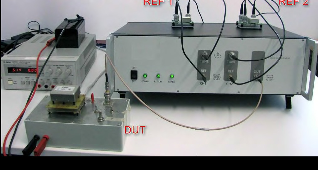 Bench photograph of the PNT with two reference OCXOs and a DUT connected on the front panel
